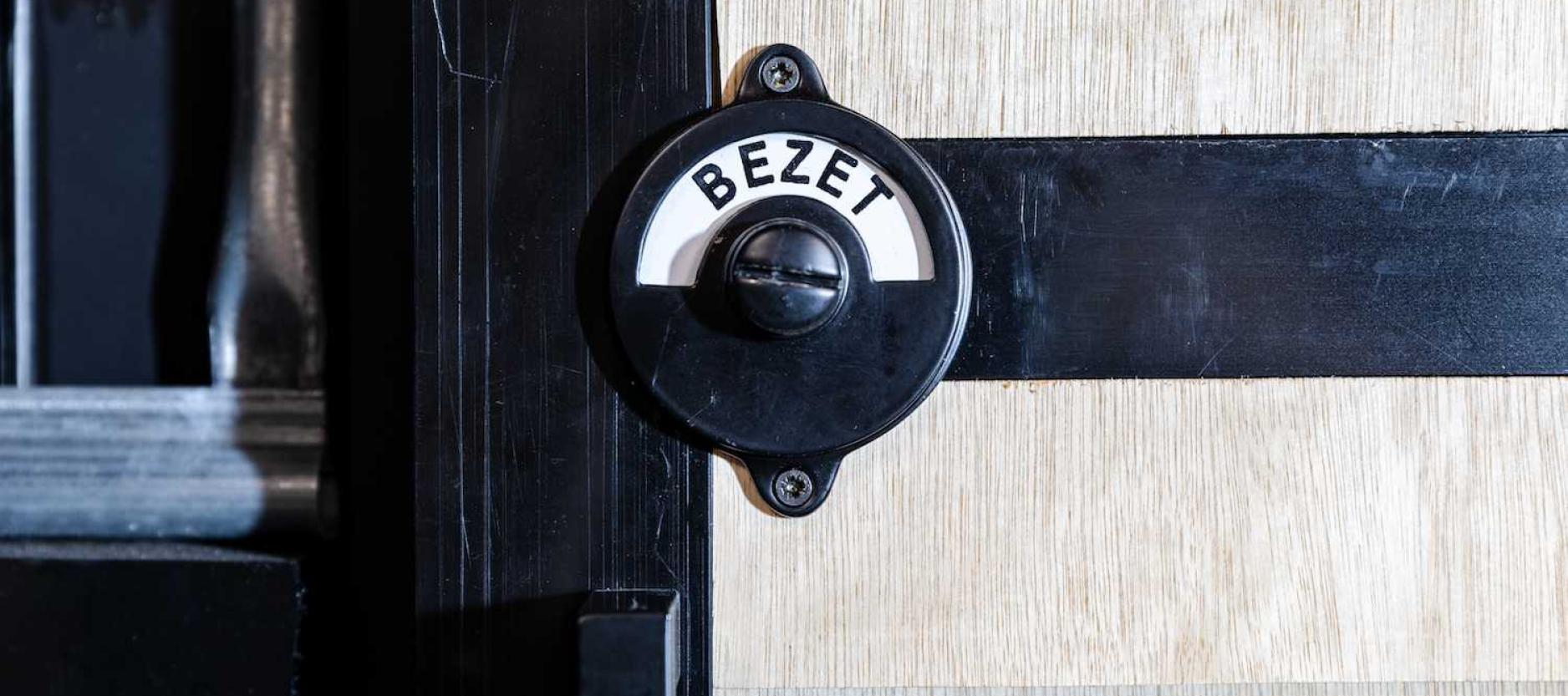 wc deur met oudewetse bezet knop, de tekst 'bezet' is zichtbaar.