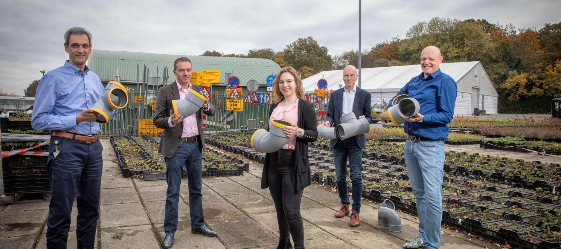 Betrokkenen op de gemeentewerf met delen kunststof rioolbuis