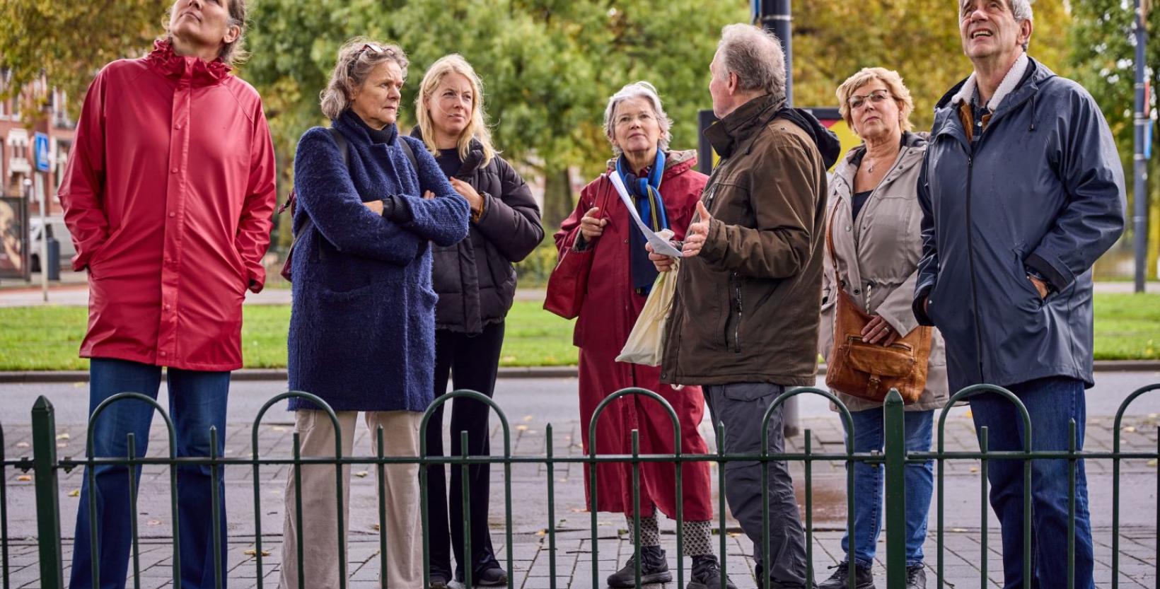 Deelnemers luisteren op straat naar hun gids